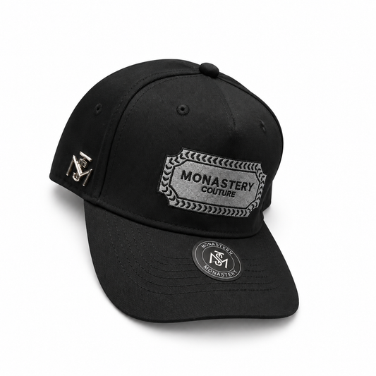 Gorra Monastery X Couture negra con parche bordado gris en fondo blanco